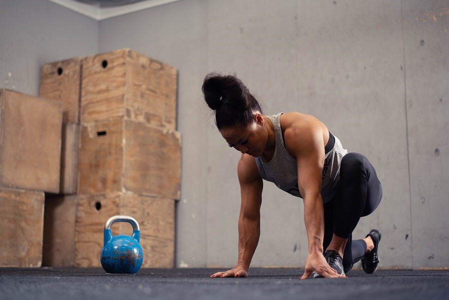 Kvinna som stretchar inne p� ett gym.