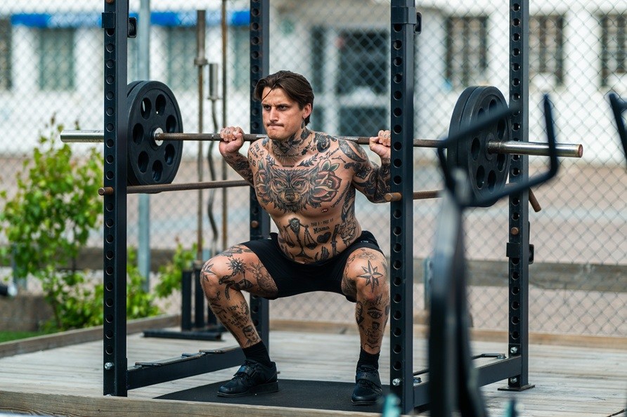 Man trnar utomhus och gr vningen knbj.