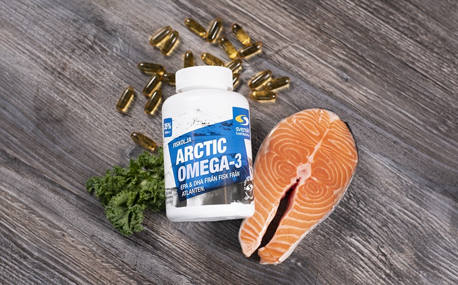 Arctic Omega 3 - Fiskolja av hög kvalité och renhet Bild på burk med Arctic Omega 3 som ligger på ett bord, några kapslar ligger på bordet samt en laxfilé.