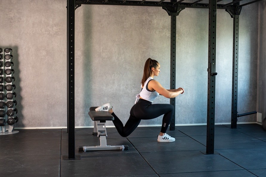Kvinna gr trningsvningen bulgarian split squat. 