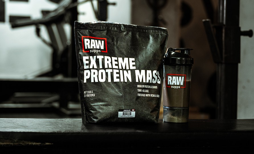 RAW SUPPS Extreme Protein Mass placerad bredvid en RAW-shaker i mrk gymmilj.