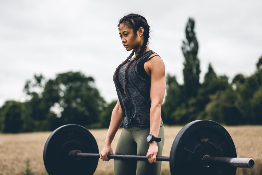 Kvinna som lyfter en skivstng med vikter