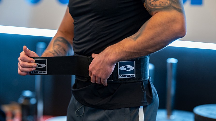 En man sp�nner ett lyftarb�lte i nylon runt midjan. 