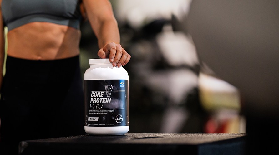 Bild p en person som hller i en burk Core Protein Pro.