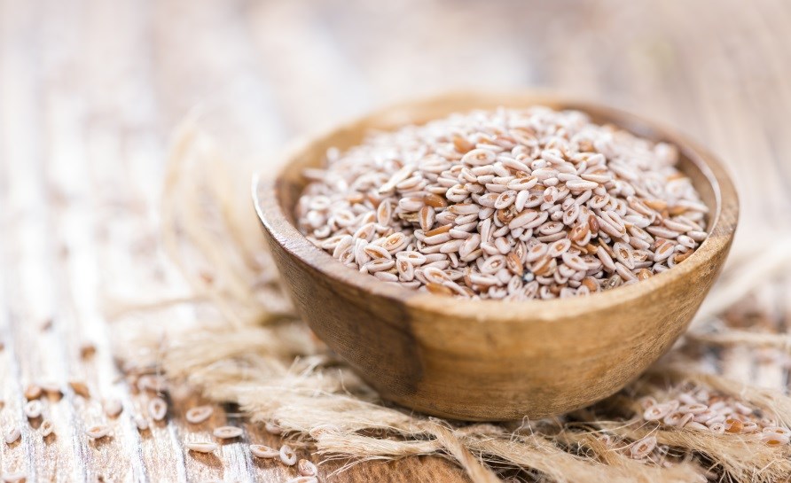 Psylliumfrön i en träskål på ett bord. Psylliumfrön i en träskål på ett bord.