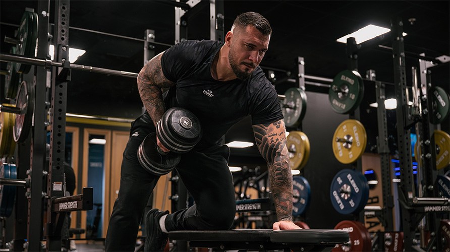 En man utfr vningen hantelrodd.