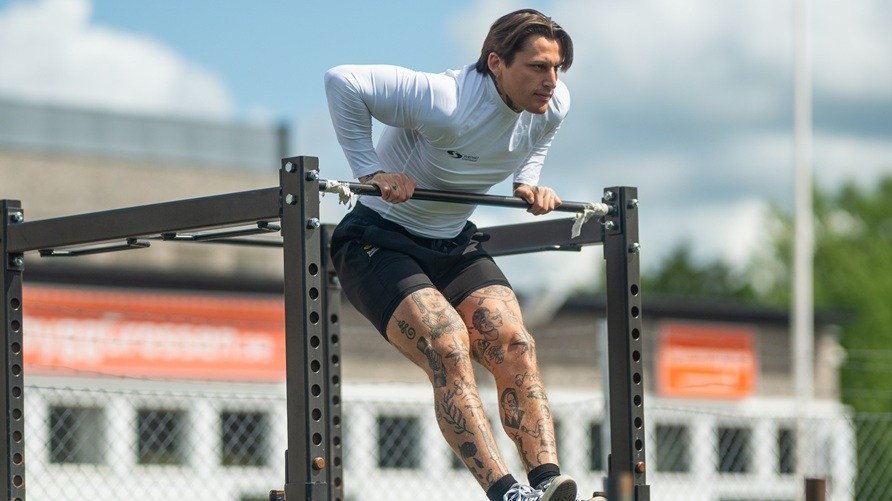 Man som trnar ute och gr en muscle-up.