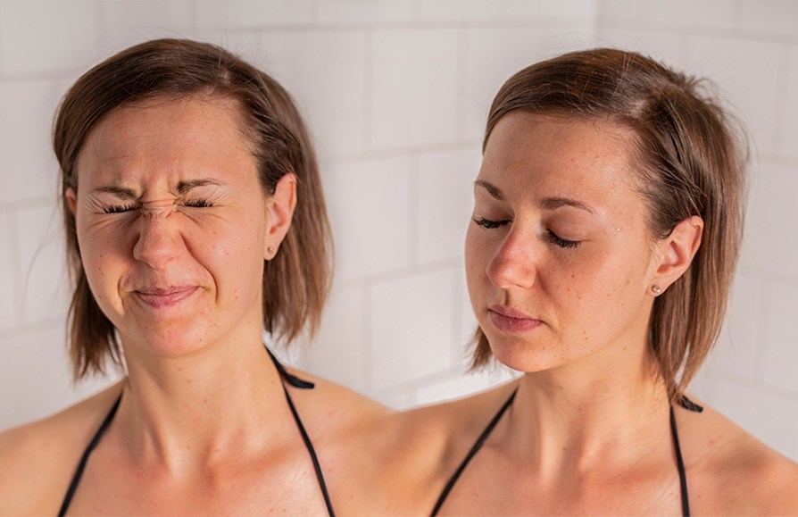 Tjej visar hur du sprayar spraytan i ansiktet.