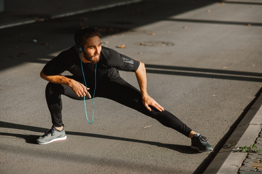 Man som stretchar utomhus.