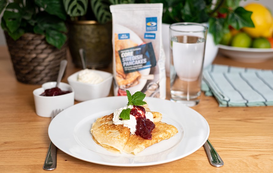 Svenska tunna pannkakor toppat med grdde och sylt. Uppdukat p vit tallrik.