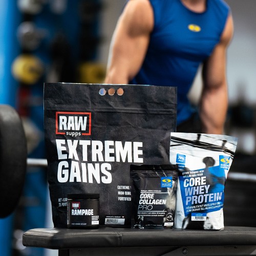 RAW Extreme Gains och andra produkter str i frgrunden framfr en person som kr marklyft. 